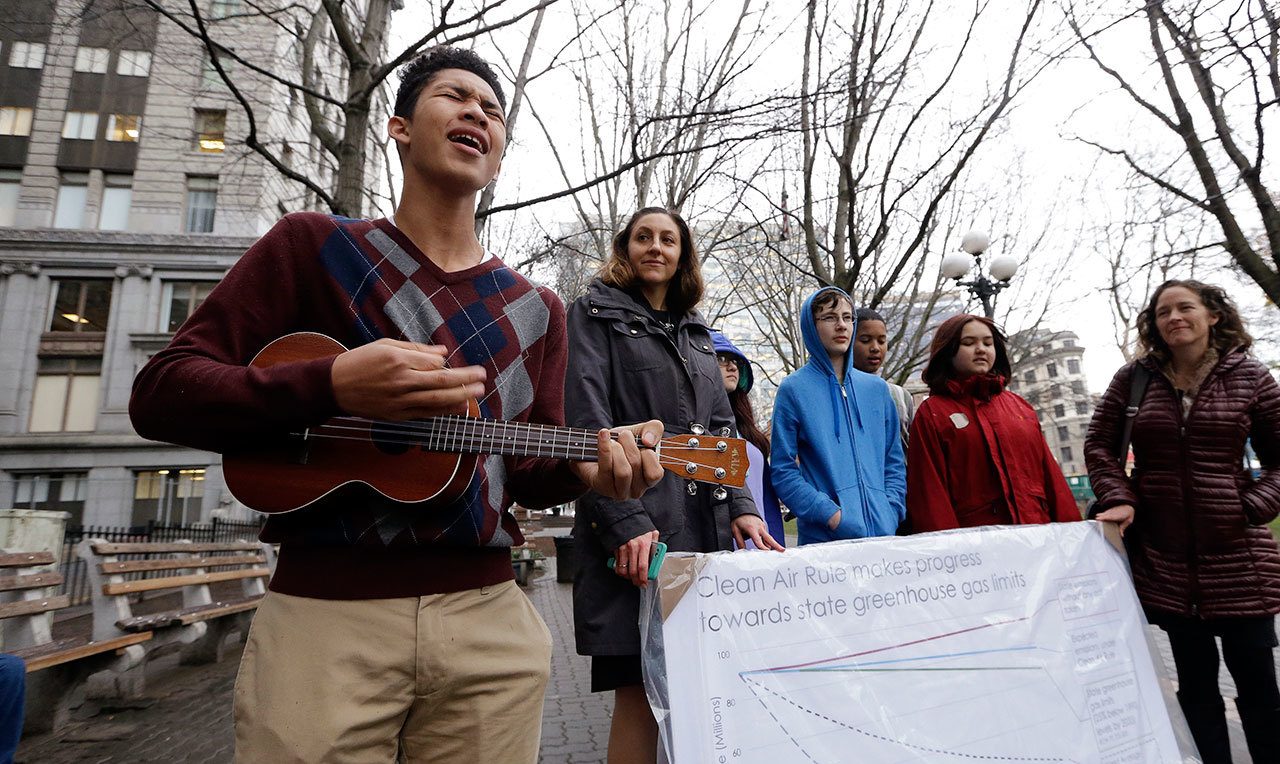 Petitioner Aji Piper, left, starts off a news conference with a song as he stands with other children asking a court to force state officials to adopt new rules to limit carbon emissions Tuesday in Seattle. (Elaine Thompson/The Associated Press)