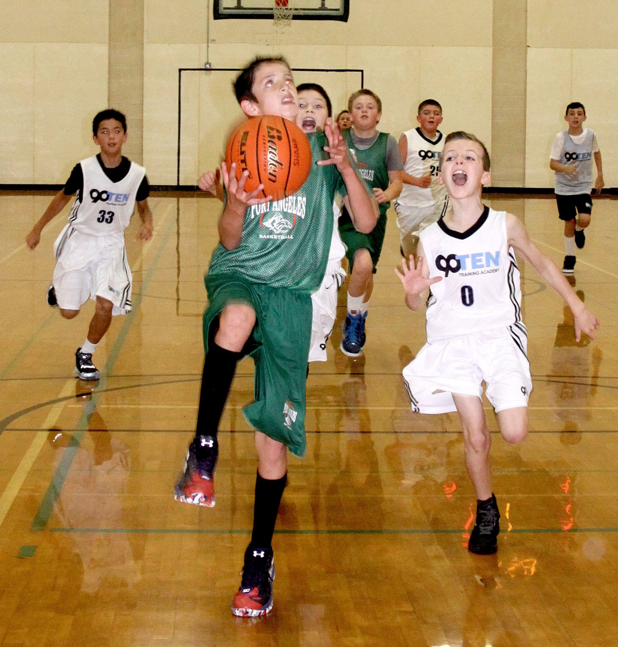 David Logan/For the Peninsula Daily News                                Tyler Hunter of the 6th-grade Port Angeles team drives past Eric Gyekis from Tumwater.