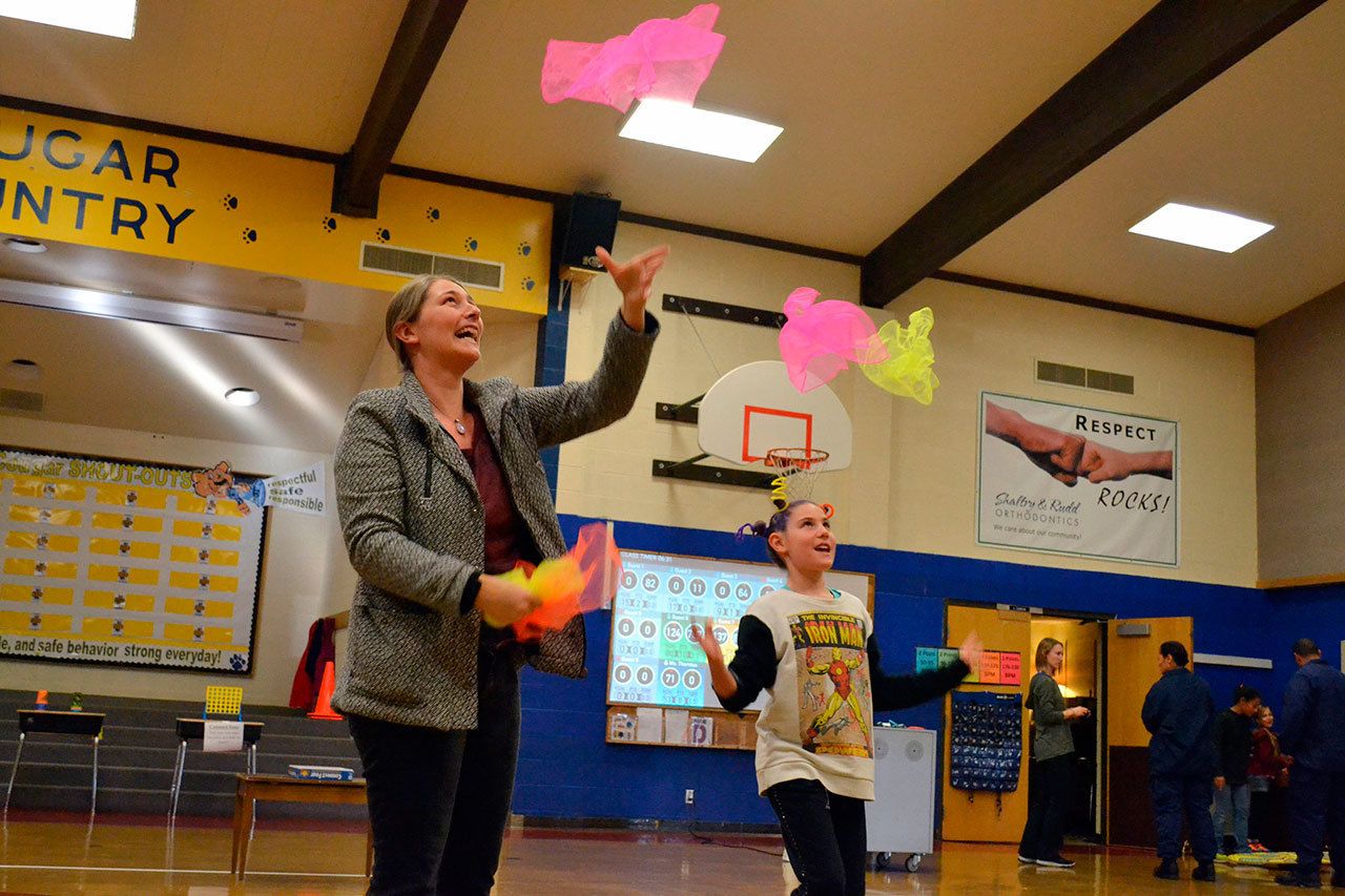 Fourth-grader Allie Rush, 9, juggles with her mom, Melissa Gatchet, during conferences at Helen Haller Elementary School to demonstrate how the Heart Tech Plus program works. It’s one of the programs the school’s PTO is raising funds for at the Turkey Trot. (Matthew Nash/Olympic Peninsula News Group)