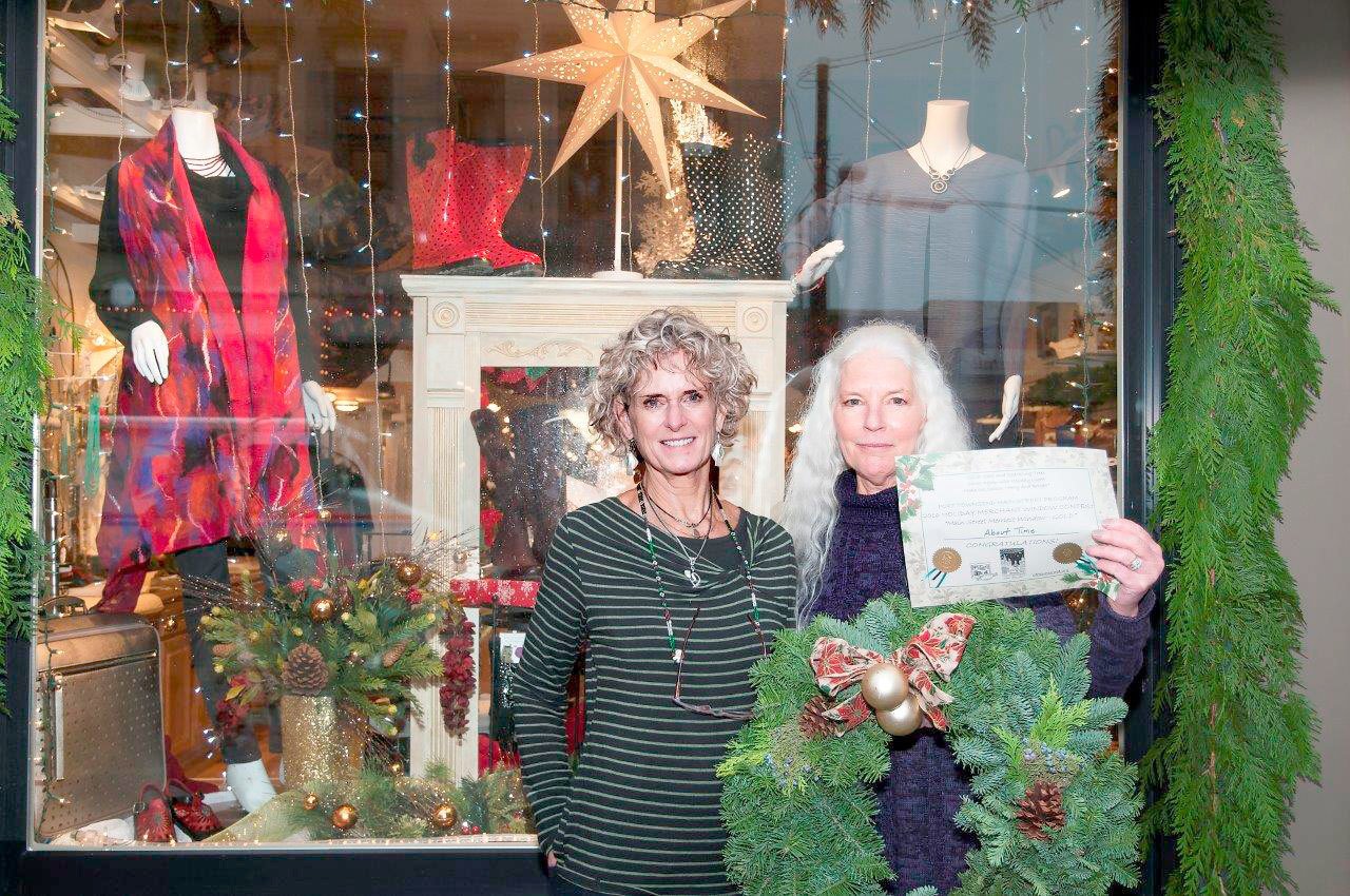 About Time staff members Jan Hopfenbeck, left, and Nancy Cherry Eifert hold a certificate that notes the store on 830 Water St. won the Port Townsend Main Street Program’s holiday display contest. (Studio J)