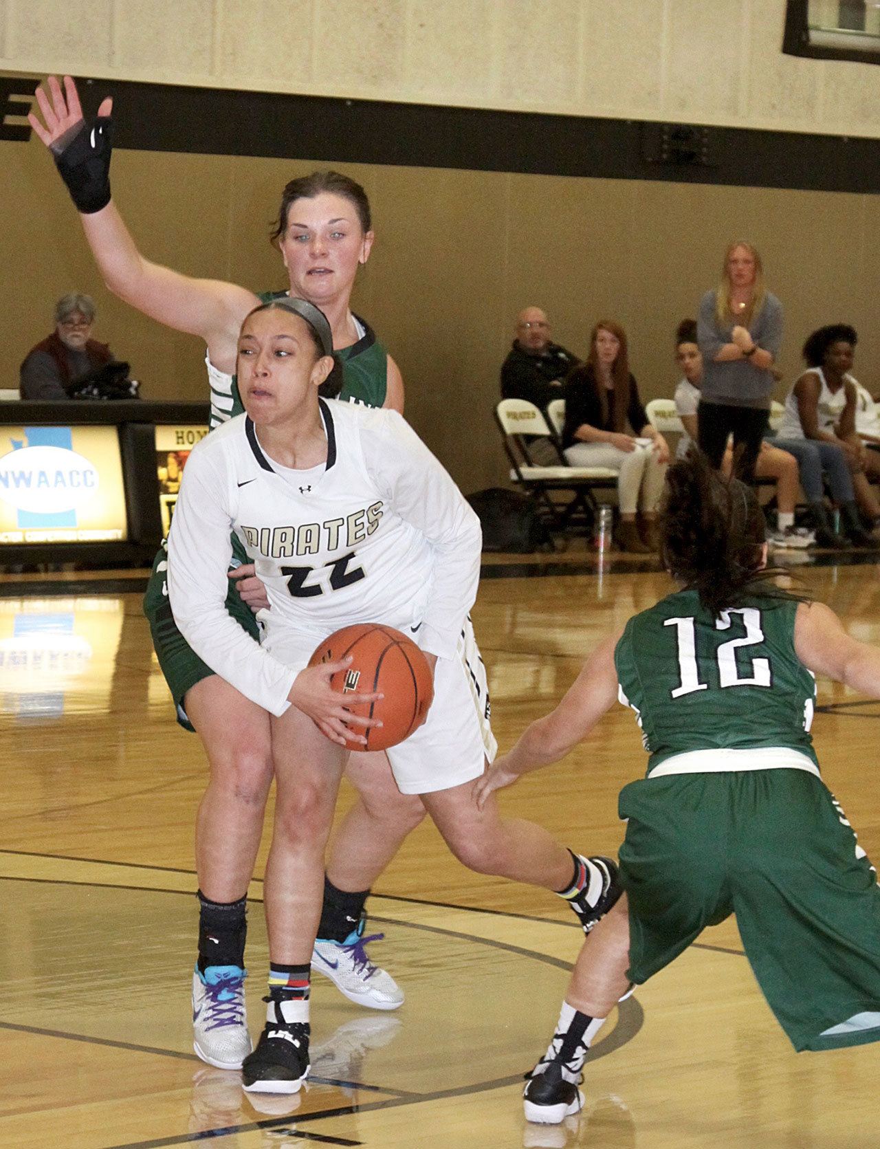 Dave Logan/for Peninsula Daily News Peninsula&rsquo;s Tiffani Smith (22), looks for help while surrounded by Highline defenders during the Pirates 73-52 win.