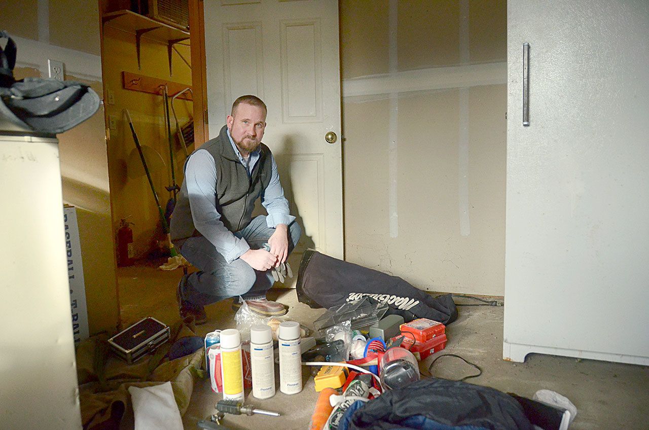 East Jefferson Little League Director Kenny Yingling stands by a pile of baseball gear, kitchen supplies and tools piled on the floor after a break-in to the Little League building in Port Hadlock on Dec. 5 and 10. (Cydney McFarland/Peninsula Daily News)
