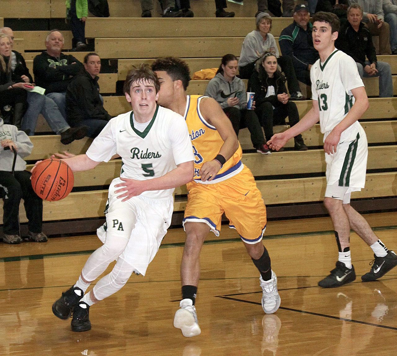 Dave Logan/for the Peninsula Daily News                                Port Angeles&rsquo; Noah McGoff, left, drives to the hoop while Bremerton&rsquo;s Diontae Madison goes for the steal during the Roughriders&rsquo; 53-44 win over the Knights.