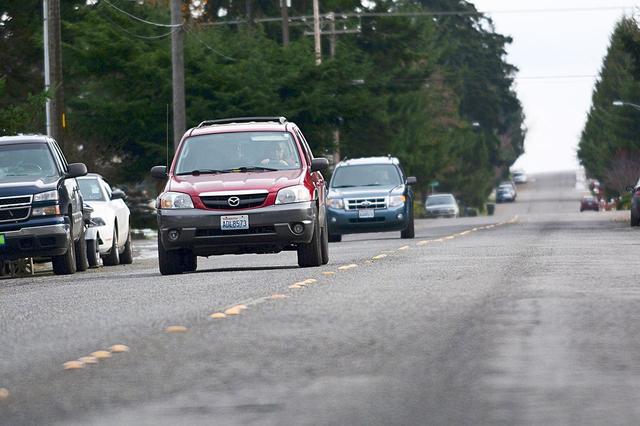 Traffic travels on West 10th Street on Wednesday, a street that Port Angeles council members identified as needing repairs. (Jesse Major/Peninsula Daily News)