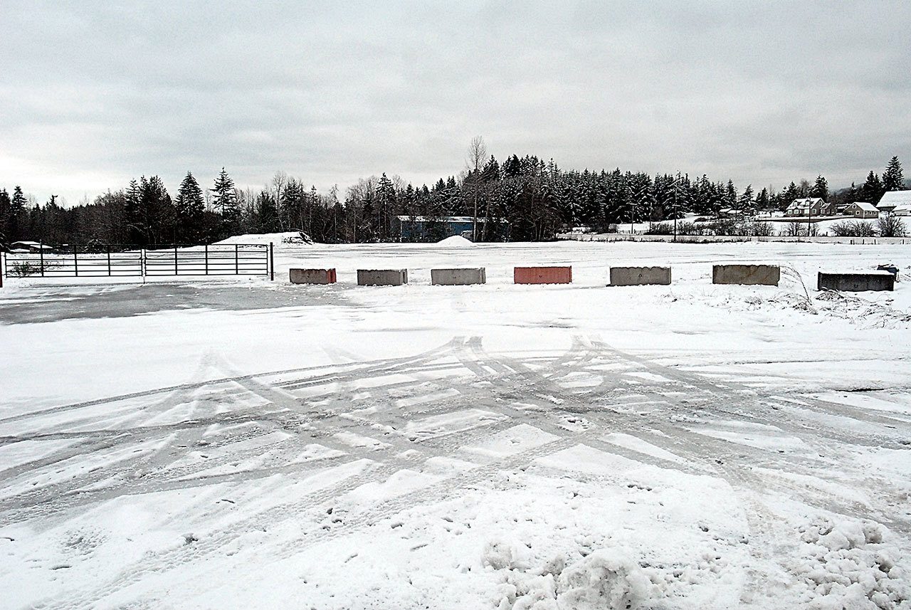 Concrete barriers and a steel gate block access to a large vacant lot along U.S. Highway 101 at Fey Road west of Port Angeles. (Keith Thorpe/Peninsula Daily News)