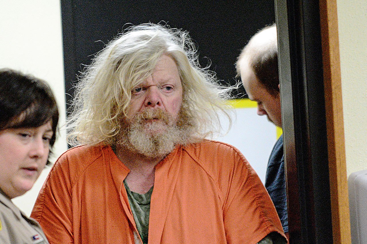 Andrew Helman, 58, accused of setting fire to his own home, is escorted into Clallam County Superior Court on Wednesday. (Jesse Major/Peninsula Daily News)​