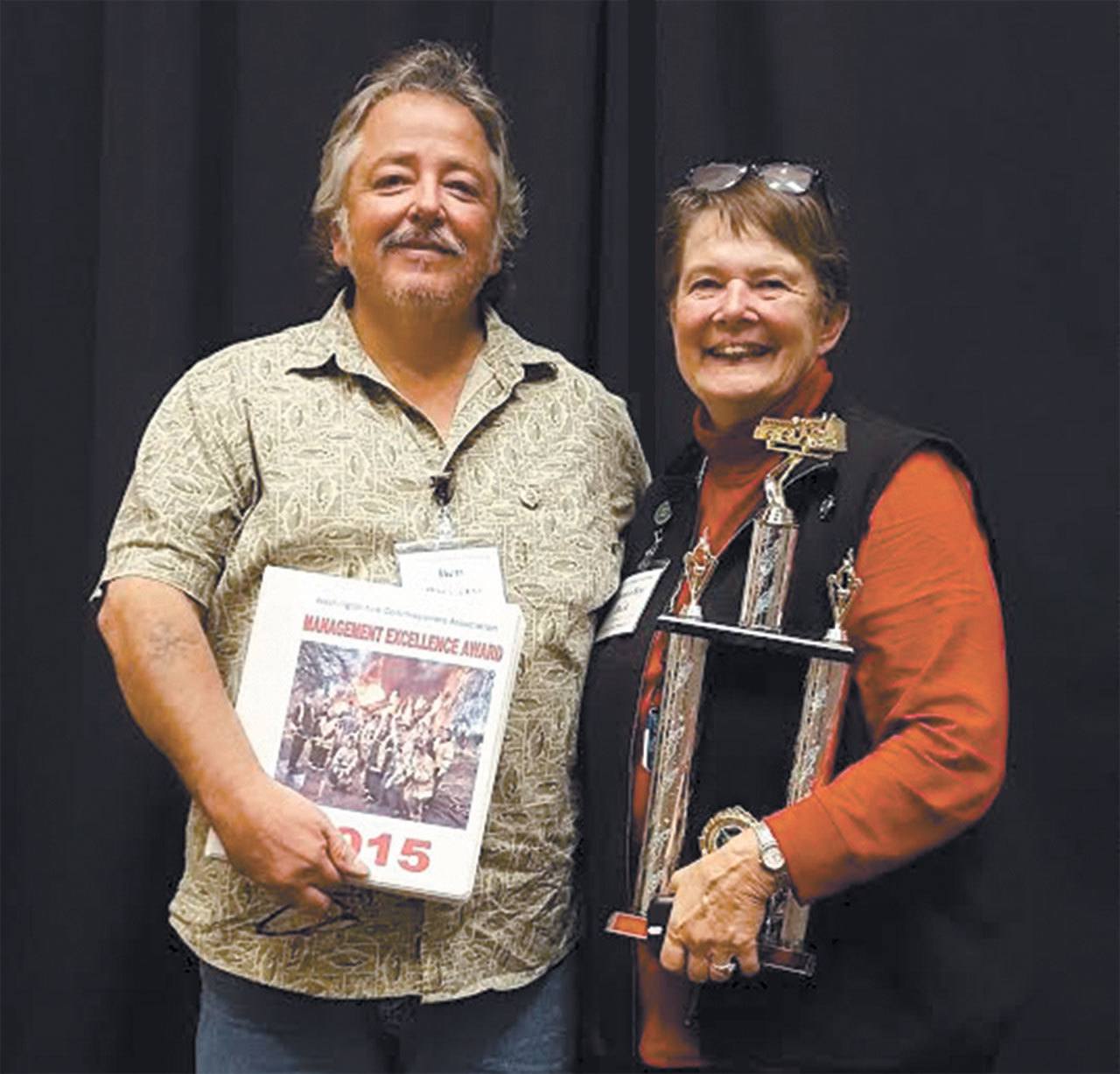 Clallam County Fire District Commissioners Ben Pacheco, left, and Donna Buck accept the first-place trophy for the Washington Fire Commissioners Association’s Management Excellence Award. (Clallam County Fire District No. 4)