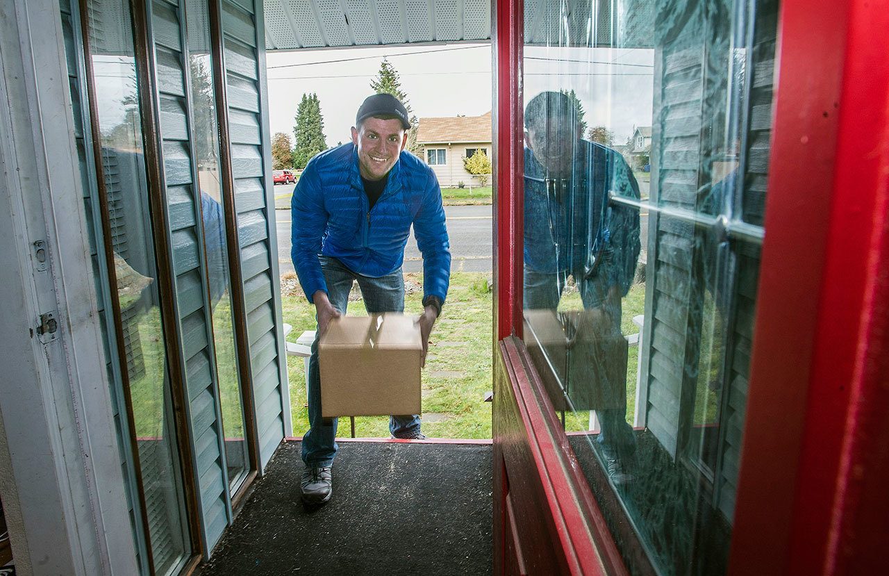 Jaireme Barrow poses for a photo in Tacoma. A box on the man’s porch sets off a 12-gauge shotgun blank when pulled by would-be thieves. (Dean J. Koepfler/The News Tribune via AP)