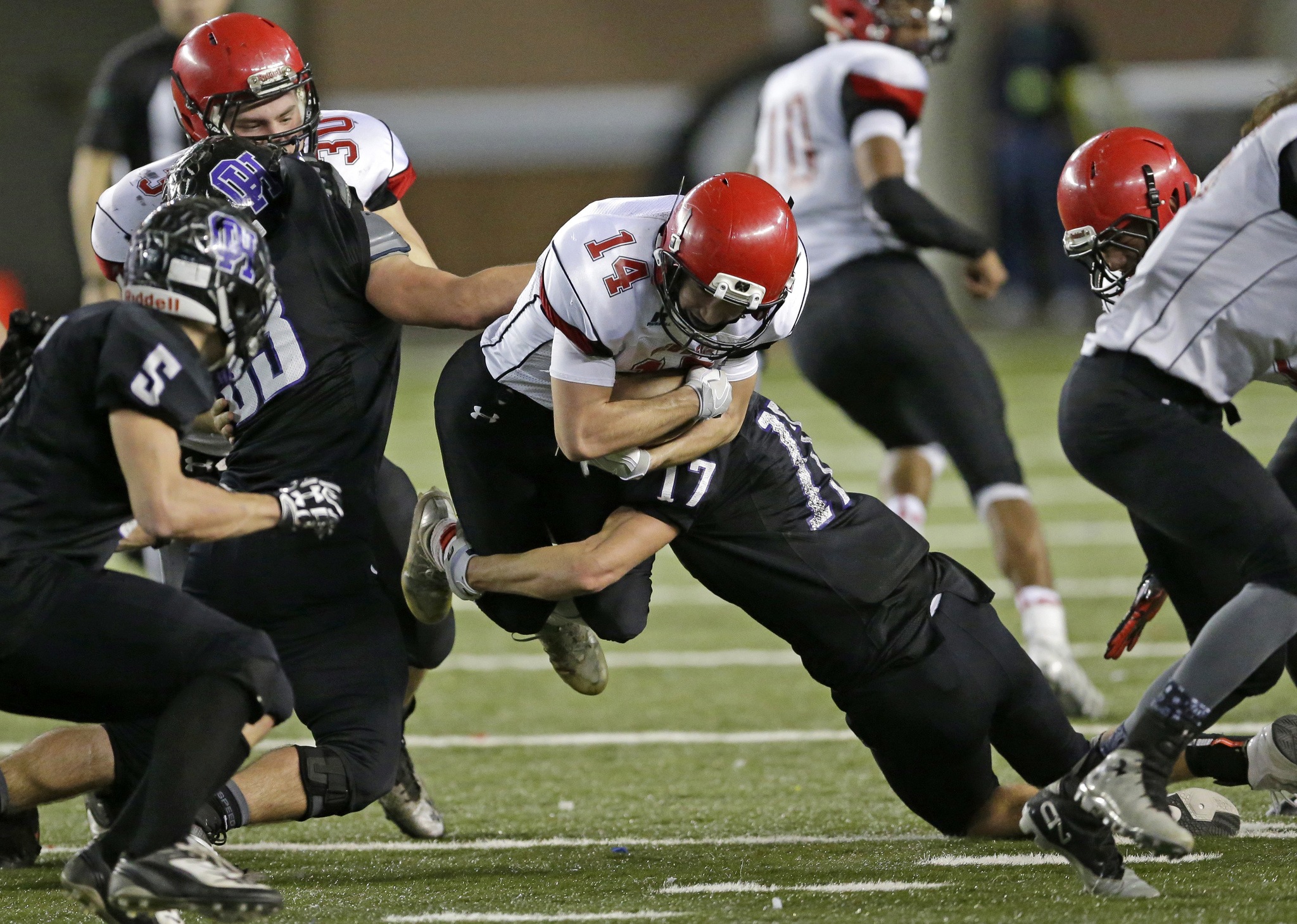 The Associated Press Neah Bay’s Cameron Buzzell (14) is tackled by Odessa-Harrington defensive linebacker John DeWulf (17) as he leaps for extra yardage during the Class 1B state football championship on Saturday in Tacoma.