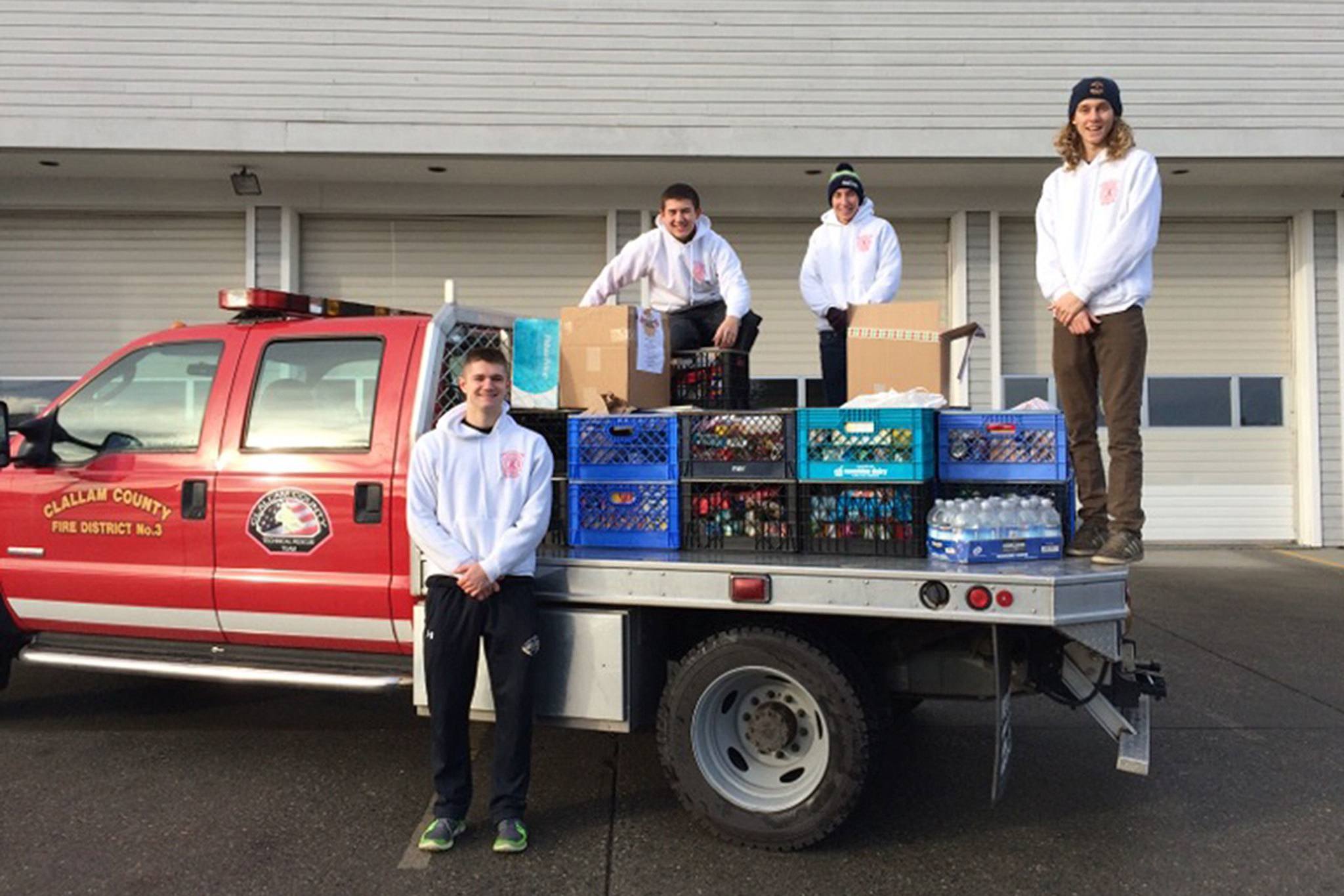 Leonard Horst                                Explorer Post 1003 members, from left, Michael Larsen, Tyler Smith, Christian Goodrich and Curtis Beery stand with the community’s donation of about 1,200 pounds of food.                                Santa’s Toy and Food Fire Brigade collected about 1,200 pounds of food and $600 for the Sequim Food Bank.
