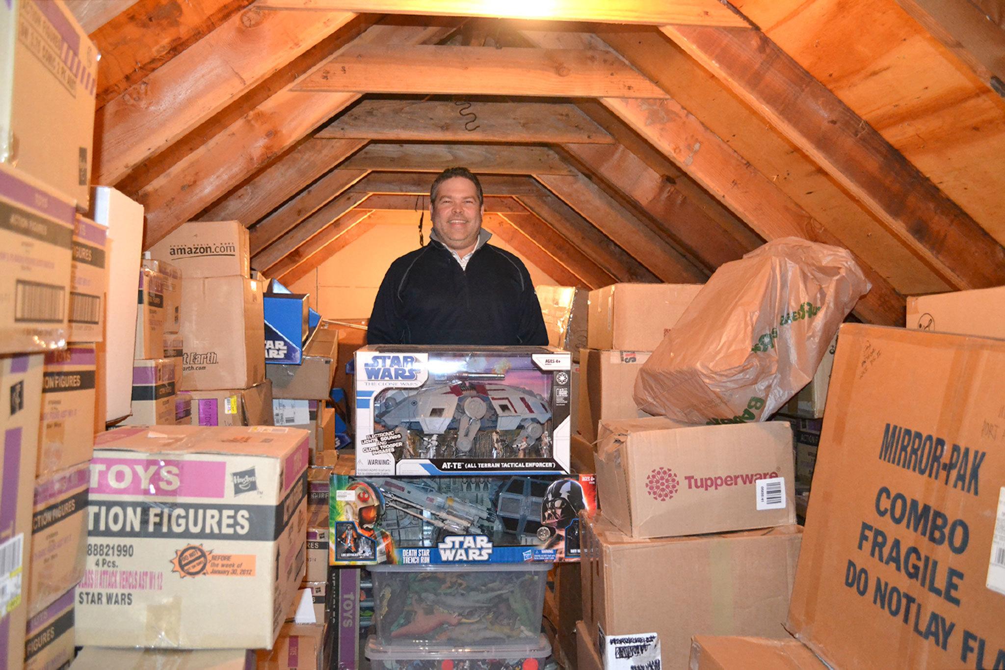 Jon Gray of Sequim stands in his attic with boxes of Star Wars toys he’s collected since the mid-1990s. He buys two of each action figure with the goal to keep one in box and a second to display. (Matthew Nash/Olympic Peninsula News Group)