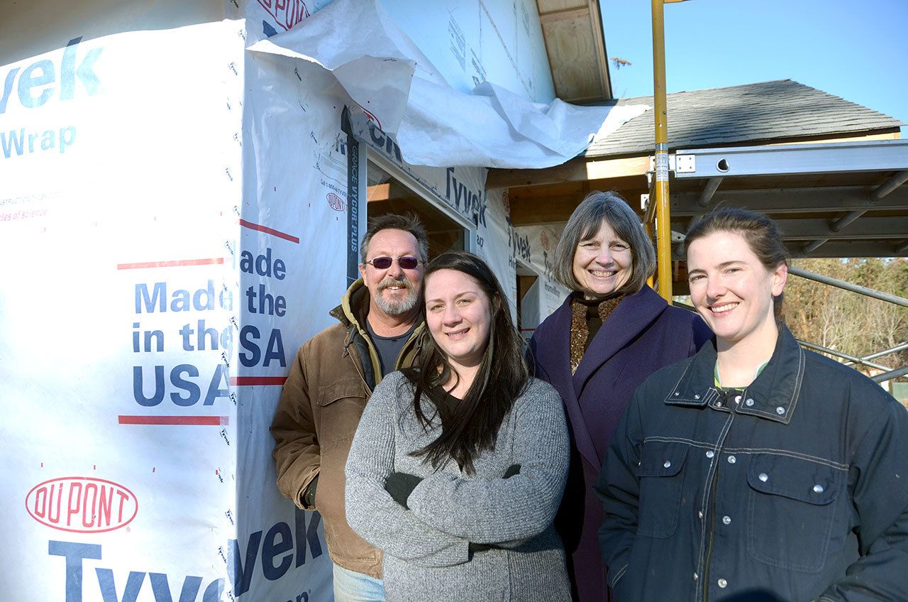 Habitat for Humanity of East Jefferson County’s Construction Manager David MacDonald, Volunteer Coordinator Tessie Taylor, Executive Director Jamie Maciejewski and AmeriCorps member Kegan Chay stand in front of one of the homes framed by Interfaith groups from Port Townsend. (Cydney McFarland/Peninsula Daily News)