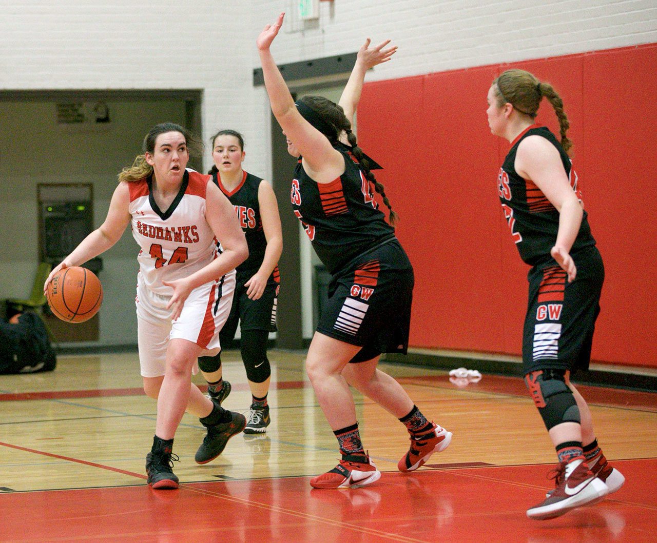 Steve Mullensky/for Peninsula Daily News Jenna Carson with the Redhawks stares down her Coupeville opponents as she gets set to drive for the basket during Olympic League action in Port Townsend on Tuesday.