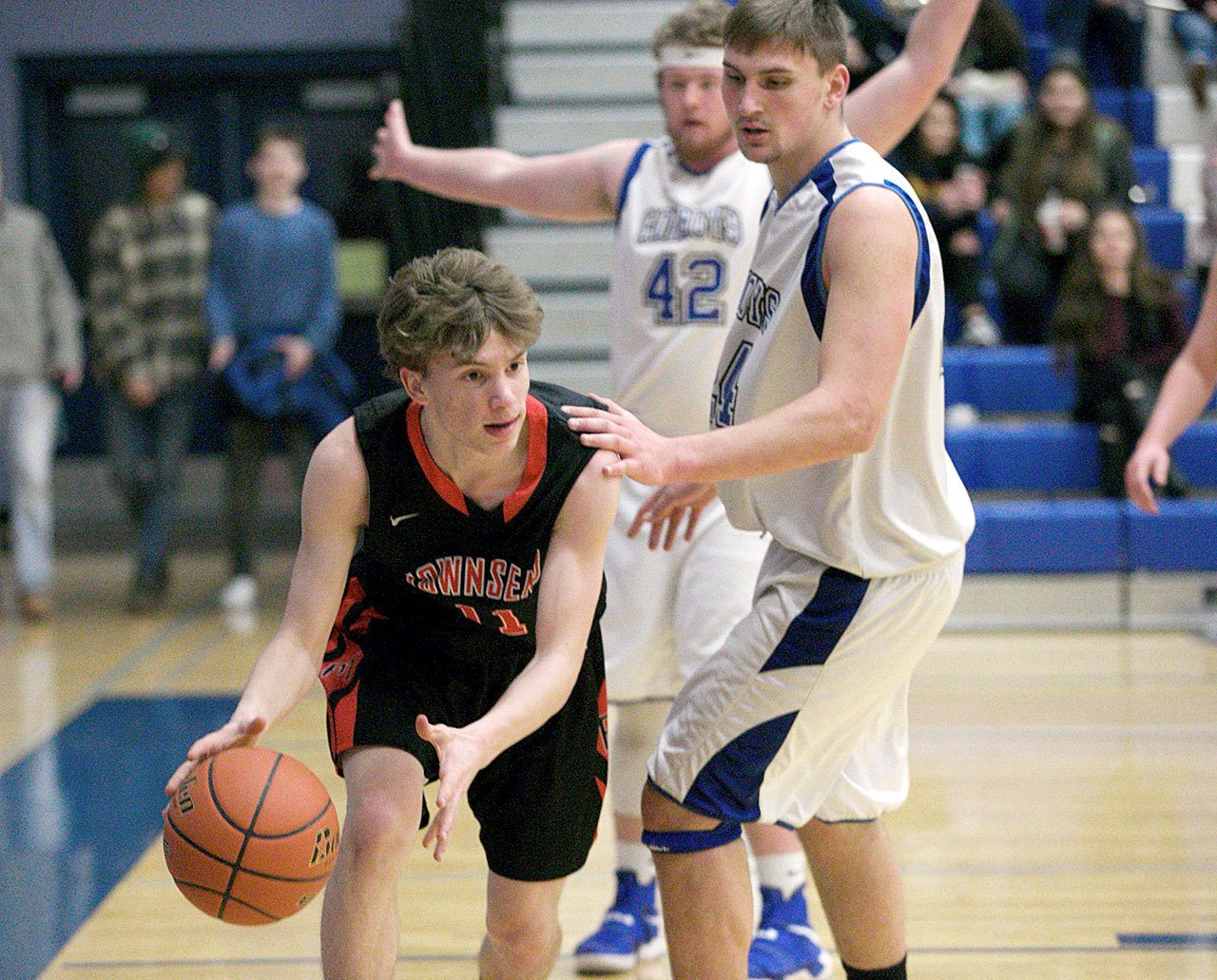 Steve Mullensky/for Peninsula Daily News Port Townsend&rsquo;s Jaden Watkins dribbles around Chimacum&rsquo;s Lane Dotson, 42, and Devyn Winkley, during Olympic League action in Chimacum on Tuesday.