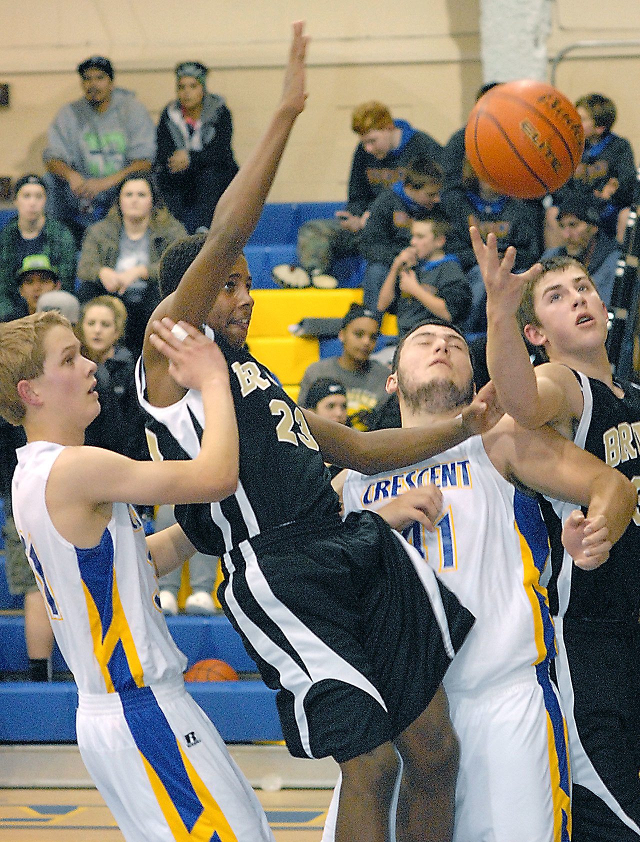 Keith Thorpe/Peninsula Daily News                                In a scramble under the hoop, Peter Johnson of Crescent, Jamari Signor of Clallam Bay, Wyatt McNeece of Crescent and Ryan McCoy of Clallam Bay fight for a rebound in the second quarter on friday at Crescent High School in Joyce.