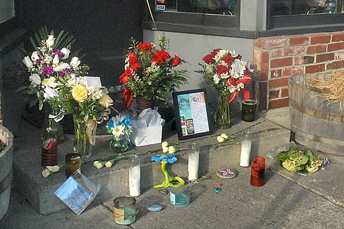 Keith Thorpe/Peninsula Daily News Pete Rennie of Port Angeles, a former patron of Van Gogh’s Gourmet Pizza & Mexican, pays his respects at a make-shift shrine to restaurant-owner Clint Darrow at the front door of the Port Angeles business on Saturday.