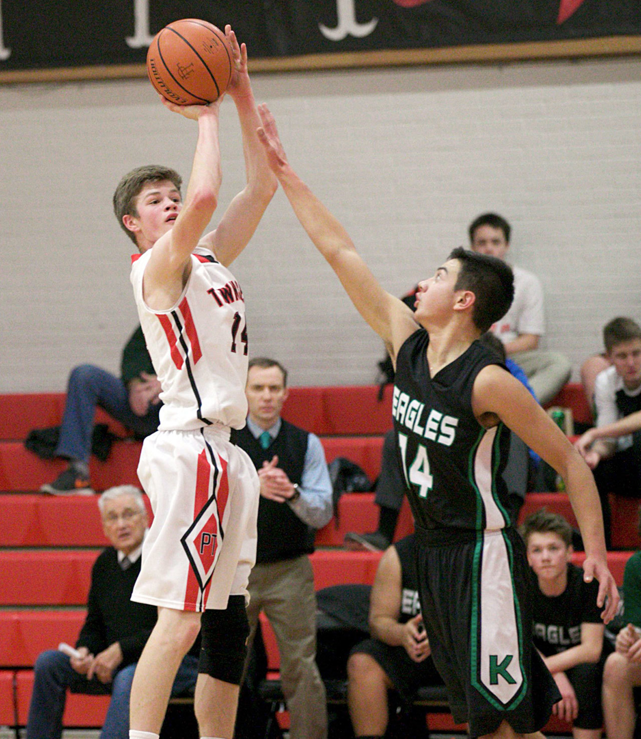 Steve Mullensky/for Peninsula Daily News                                Port Townsend’s Berkley Hill hits a 3-pointer over the outstretched arm of Klahowya defender John Hartford during the Redhawks’ win over the Eagles.