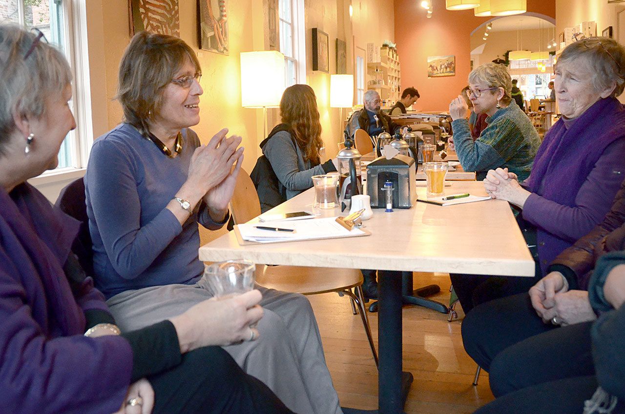 The Rev. Pam Douglas-Smith, Emelia De Souza and Kathy Ryan, from left, gather with other local women to plan a march in solidarity with demonstrations happening in Seattle and Washington, D.C., on Jan. 21. (Cydney McFarland/Peninsula Daily News)