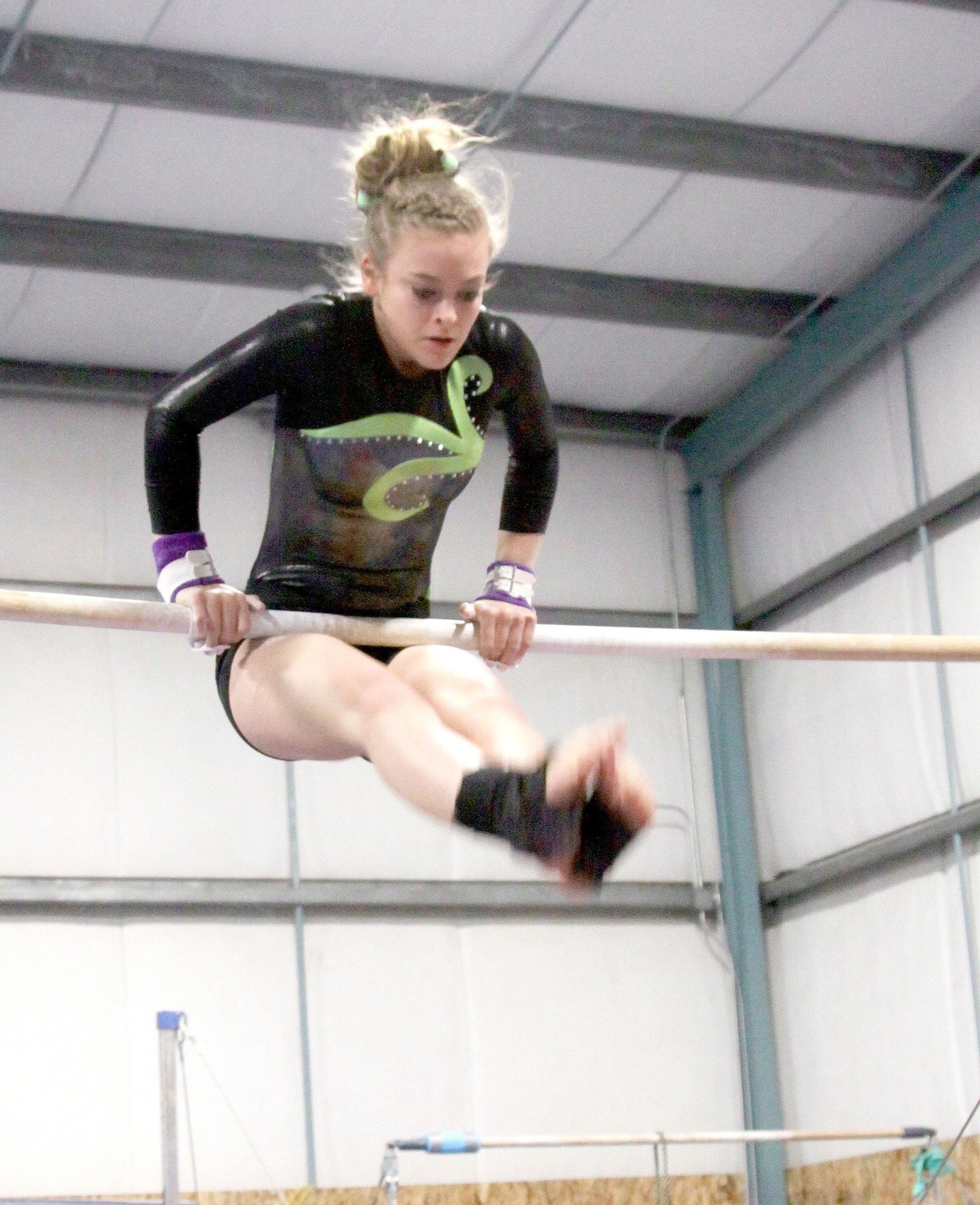 Dave Logan/for the Peninsula Daily News                                Port Angeles’ Laura Rooney competes on the uneven bars Monday in Port Angeles. The Roughriders won the meet against North Kitsap, Kingston and North Thurston.