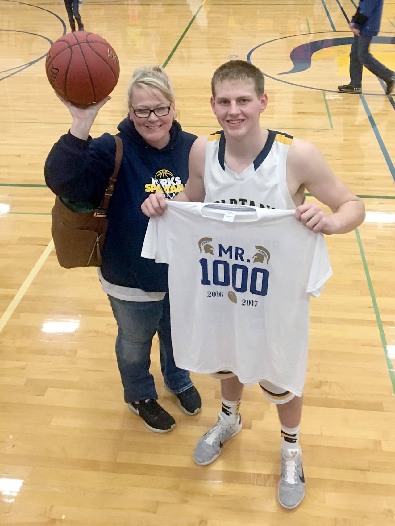 Forks senior Parker Browning recorded his 1,000th career point during the Spartans’ 74-33 win over Evergreen League foe Tenino on Tuesday. His mom Stephanie, left, holds up the game ball.