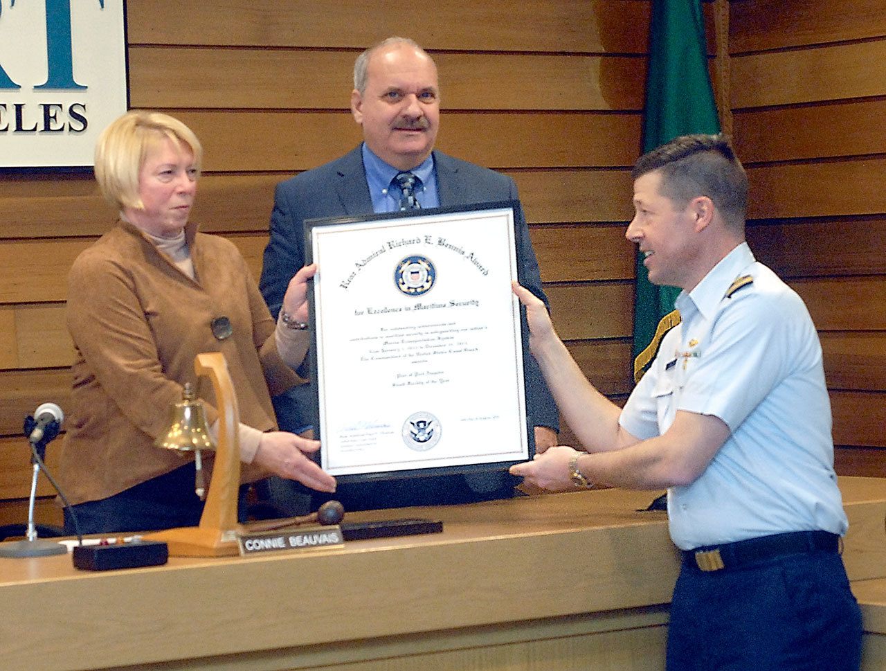 Port of Port Angeles Commissioners Connie Beauvais, left, and Steve Burke receive the Richard E. Bennis Award on Wednesday from U.S. Coast Guard Capt. Joe Raymond honoring the port for its effort to promote maritime transportation security. (Keith Thorpe/Peninsula Daily News)