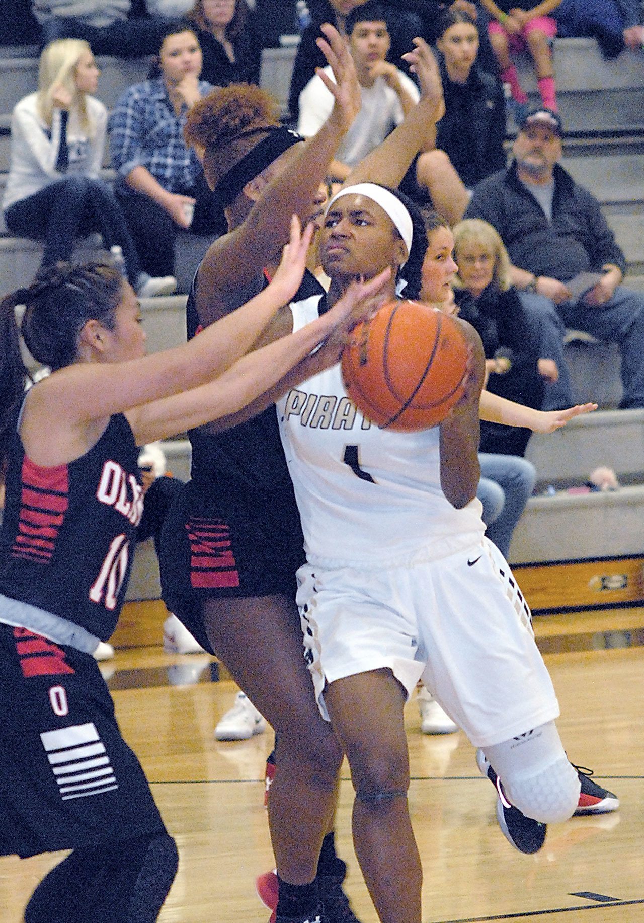 Keith Thorpe/Peninsula Daily News Peninsula’s Anaya Rodisha, right, drives to the lane past the defense of Olympic’s Libby Borogonia, left. and Zyriana Davies in the foruth quarter on Wednesday in Port Angeles.