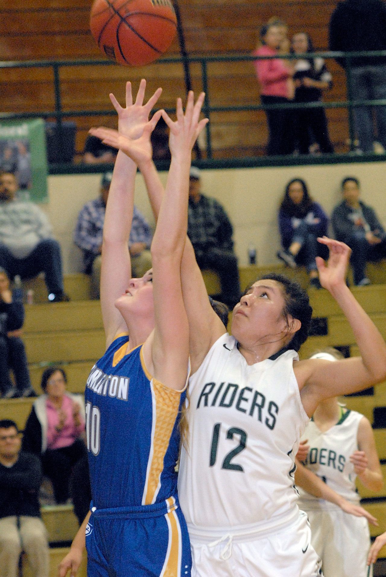 Keith Thorpe/Peninsula Daily News Bremerton’s Sophia Smith, left, and Port Angeles’ Cheyenne Wheeler fight for a rebound in the second quarter on Friday night at Port Angeles High School.