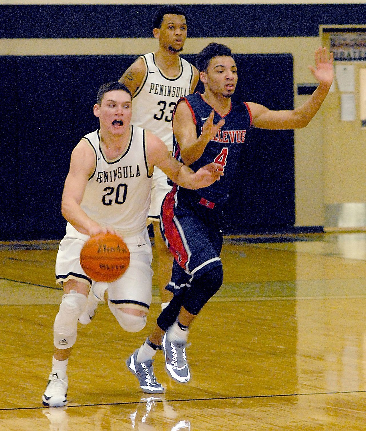 Keith Thorpe/Peninsula Daily News                                Peninsula’s Cole Rabedeaux, left, drives downcourt in front of Bellevue’s Trey Nelson in the first half on Saturday in Port Angeles. Following behind is Peninsula’s Kevin Baker.