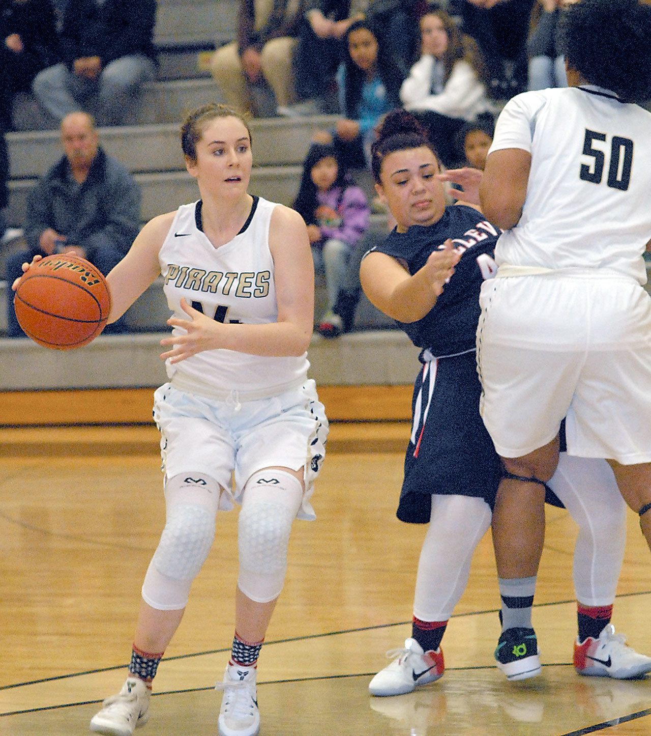 Keith Thorpe/Peninsula Daily News Peninsula’s Alicia Dugan, left, receives help from teammate Tai Thomnas, right, by blocking Bellevue defender Martina Mason in the opening minutes of the second quarter on Saturday in Port Angeles.