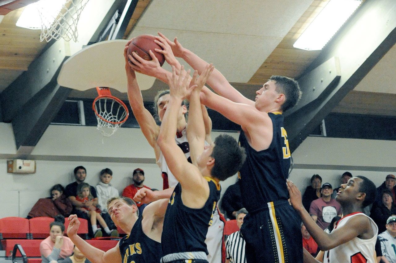 Lonnie Archibald/for Peninsula Daily News Forks&rsquo; Parker Browning left, Cole Baysinger and Marky Adams challenge Neah Bay&rsquo;s Cole Svec for the rebound while Anthony Bitegeko looks on.
