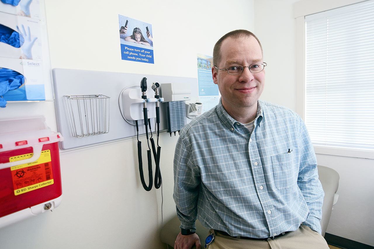 Dr. Jeff Weller of Peninsula Children’s Clinic sits in one of the exam rooms in the clinic’s new building. (Jesse Major/Peninsula Daily News)
