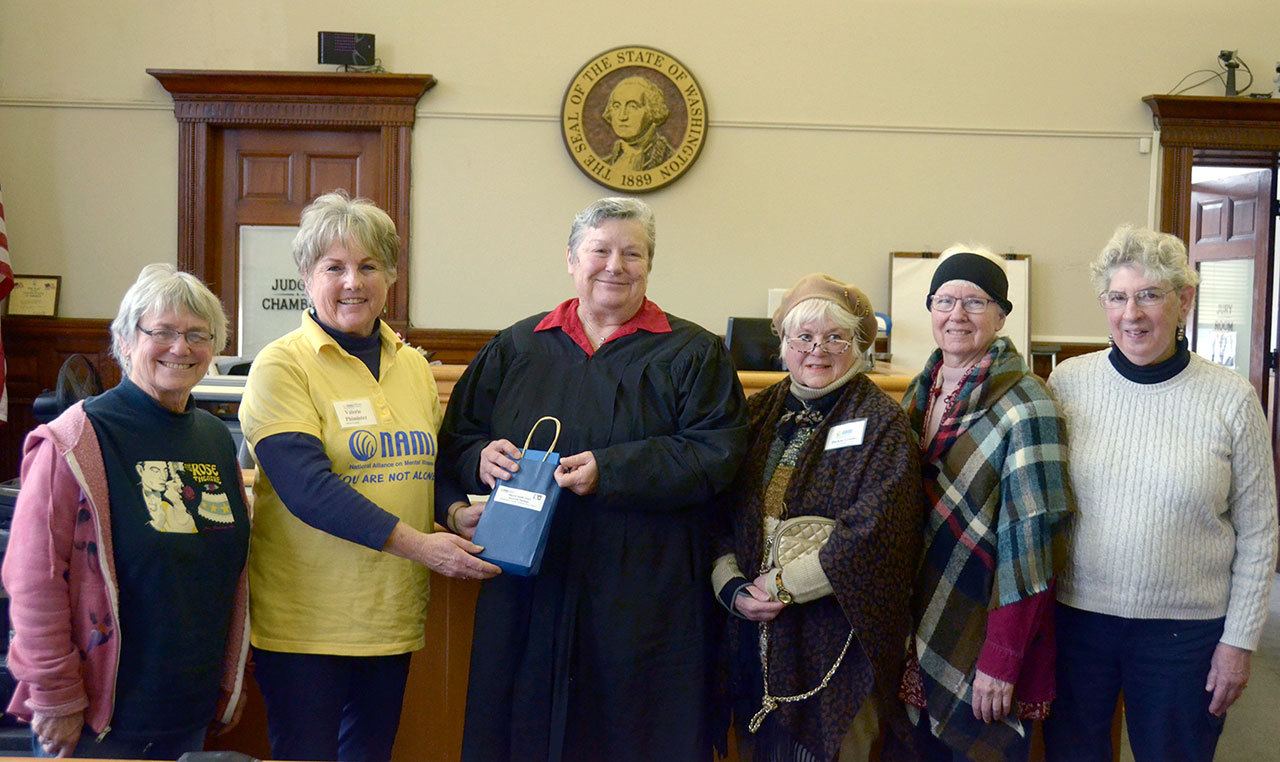 From left, Liz Berman, Valerie Phimister, Darlene Grunke Sanders, Lucinda Eubank and Sydney Keegan of the Jefferson County National Alliance on Mental Illness present over $500 worth of movie gift cards to District Court Judge Jill Landes, who runs Jefferson County’s mental health court. (Cydney McFarland/Peninsula Daily News)