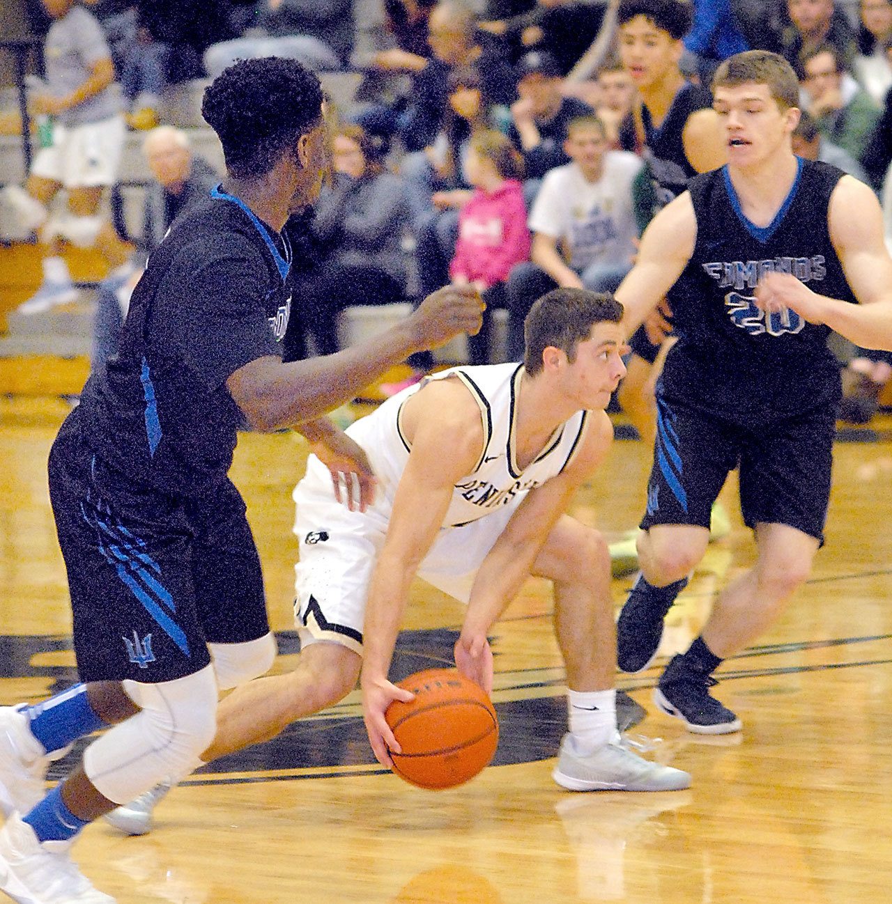 Keith Thorpe/Peninsula Daily News Peninsula’s Jalon MCCullough, center, picks up a loose ball as Edmonds’ Chiagozie Ezeokeke, left, and Mitch Wetmore try to close in on Saturday night on Peninsula’s Port Angeles campus.