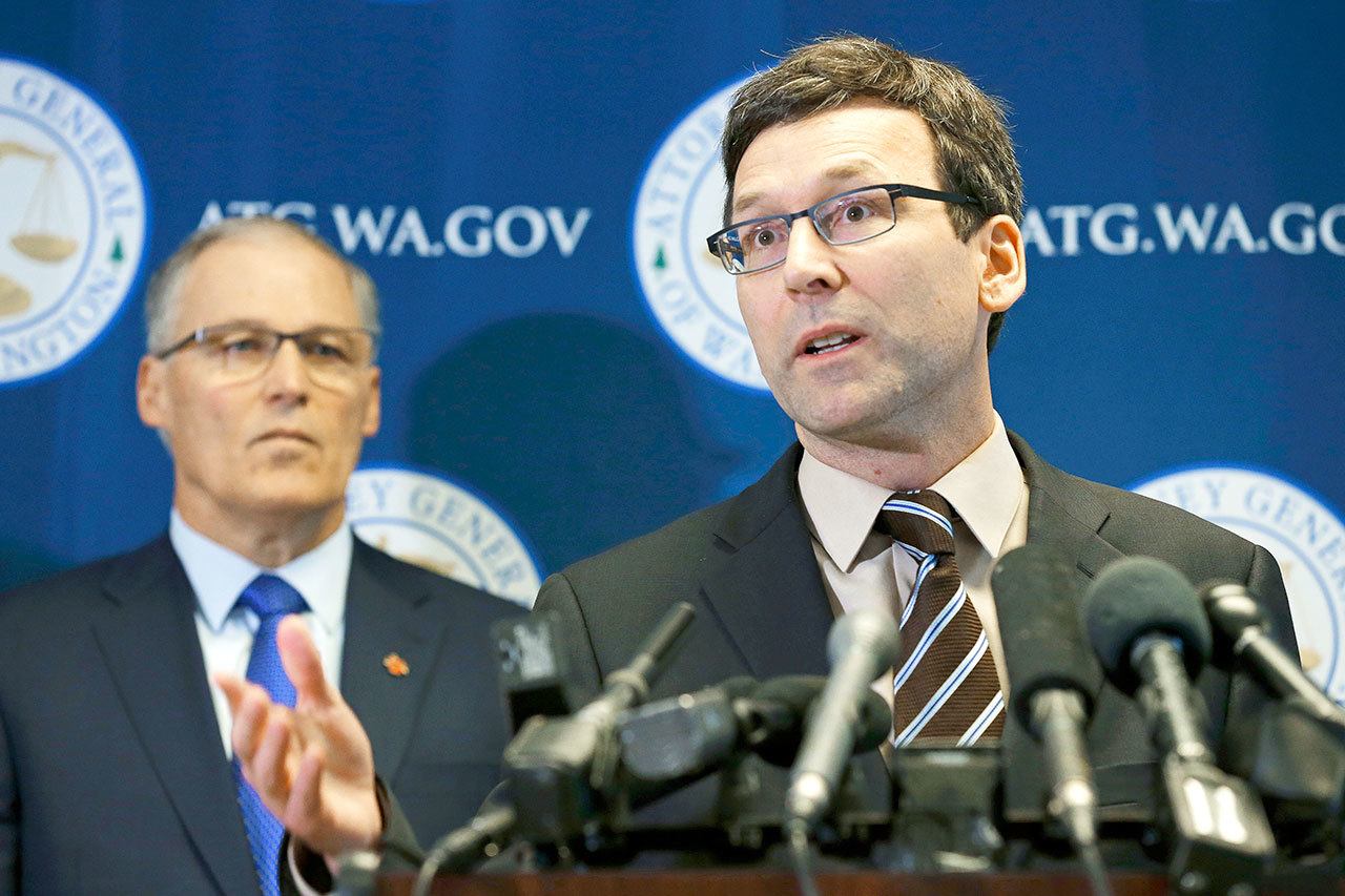 State Attorney General Bob Ferguson, right, talks to reporters as Gov. Jay Inslee, left, looks on Monday in Seattle. Ferguson announced that he is suing President Donald Trump over an executive order that suspended immigration from seven countries with majority-Muslim populations and sparked nationwide protests. (Ted S. Warren/The Associated Press)