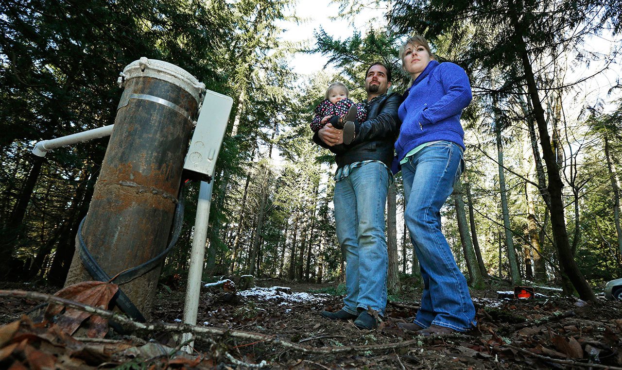 Bud Breakey and his wife, Deborah, with their daughter Kaylin, 15 months, by the water well they paid to drill on property they own near Bellingham, where they hope to eventually build a house. (Ted S. Warren/The Associated Press)
