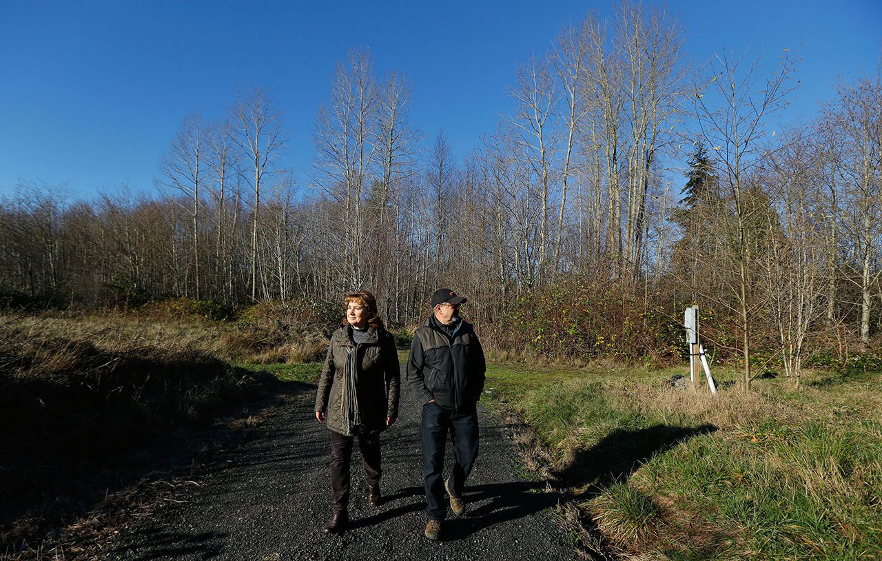 Gennadiy Skachkov and his wife, Olga, walk on the 15-acre parcel of land they own near Ferndale. The couple bought the land as an investment more than 10 years ago but now are finding it difficult to sell to a potential homebuilder, even though it has a well and power in place, due to an October decision by the state Supreme Court that said Whatcom County failed to protect water resources by allowing new wells to reduce flow in streams for fish and other uses. (Ted S. Warren/The Associated Press)