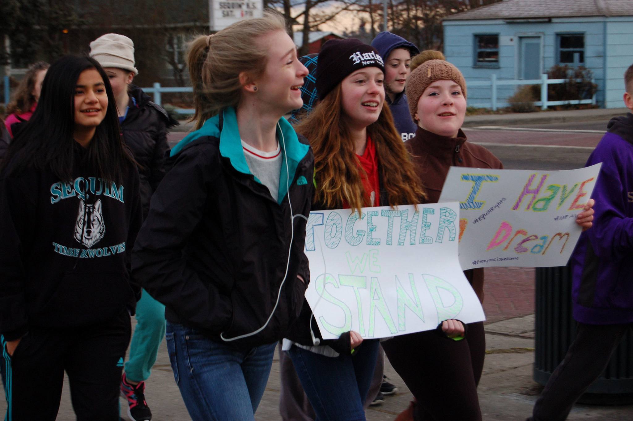 Eighth-graders Olivia Preston, right, and Mary Mcaller, center, hold signs alongside Maya Reiter during the Sequim Middle School Martin Luther King Day Jr. walk.