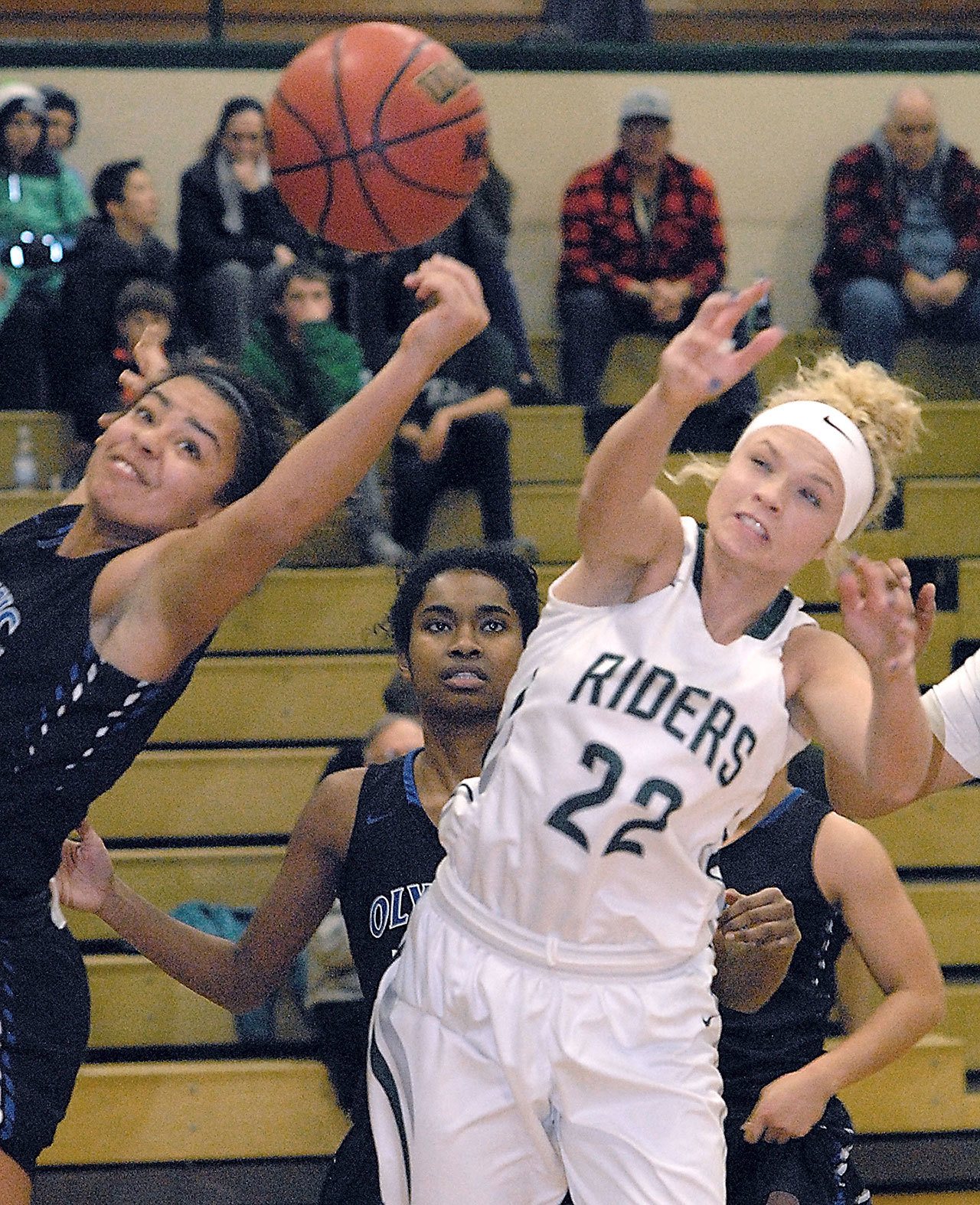 Keith Thorpe/Peninsula Daily News Port Angeles&rsquo; Natalie Steinman, right, fights for a rebound with Olympic&rsquo;s Kiki Mitchell, left, as Olympic&rsquo;s Kahlishia Grant looks on during the second quarter on Tuesday at Port Angeles High School.