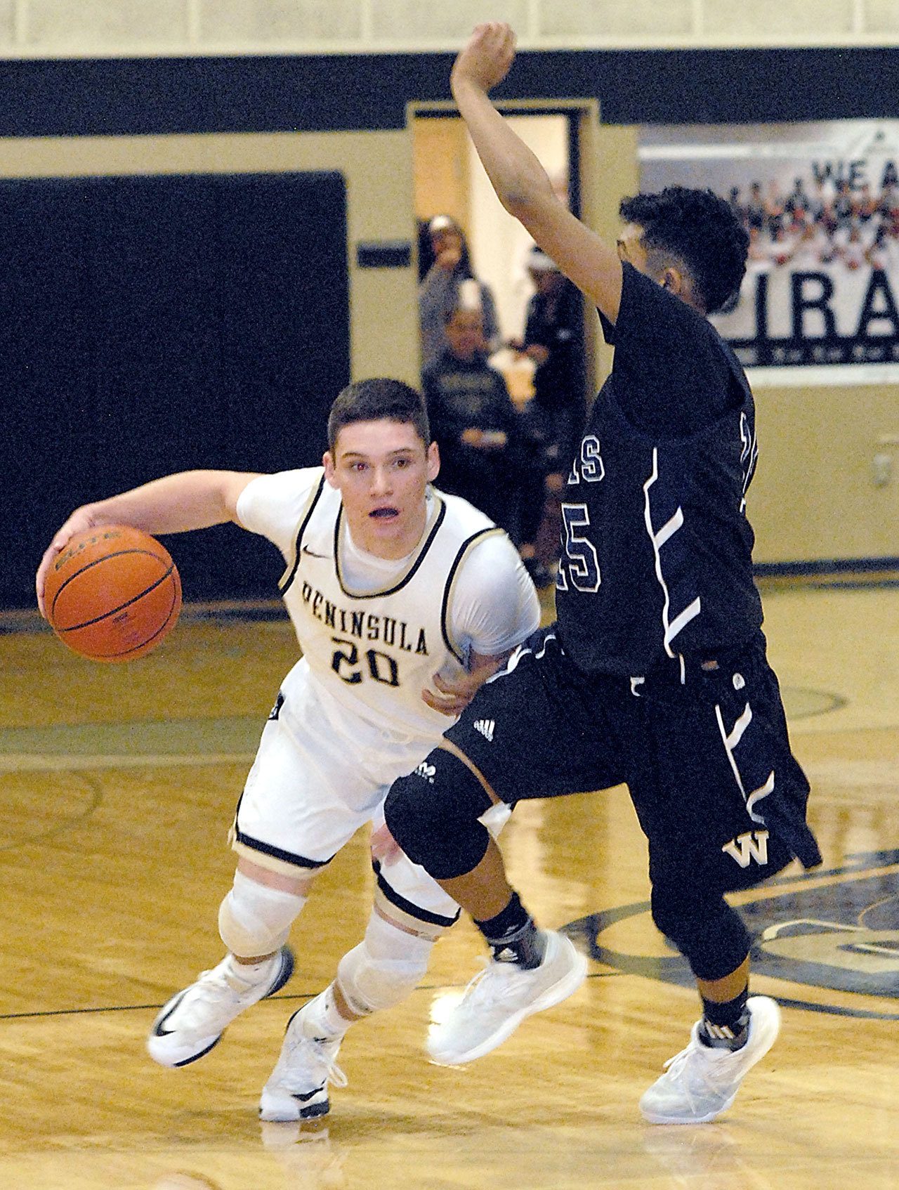 Keith Thorpe/Peninsula Daily News Peninsula’s Cole Rabedeaux, left, drives past Whatcom’s Dante Lewis in first-half action on Wednesday in Port Angeles.