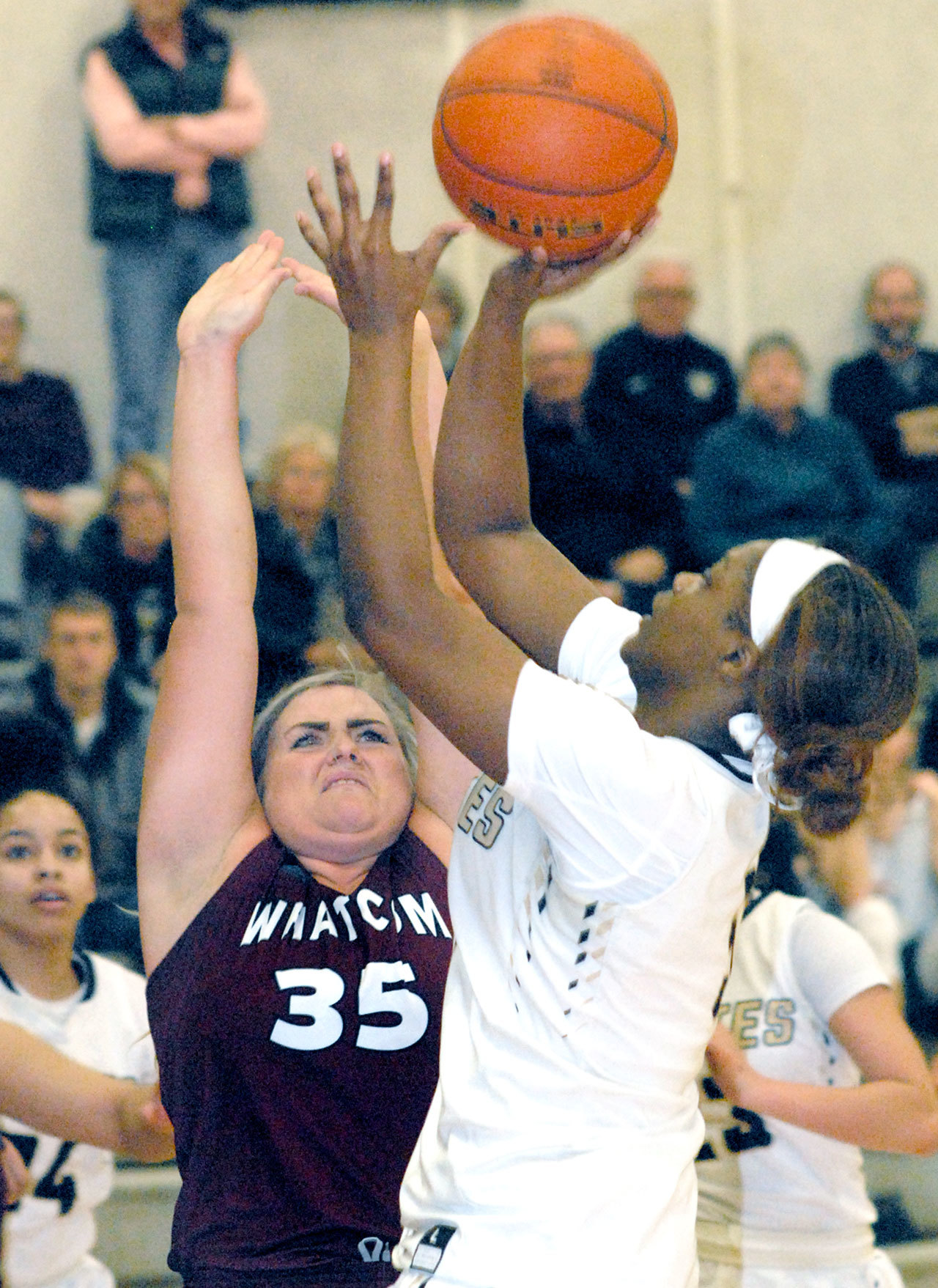 Keith Thorpe/Peninsula Daily News Peninsula’s Jenise McKnight, right, takes the layup past the defense of Whatcom’s Lindsey Honeycutt in third-quarter action on Wednesday in Port Angeles.