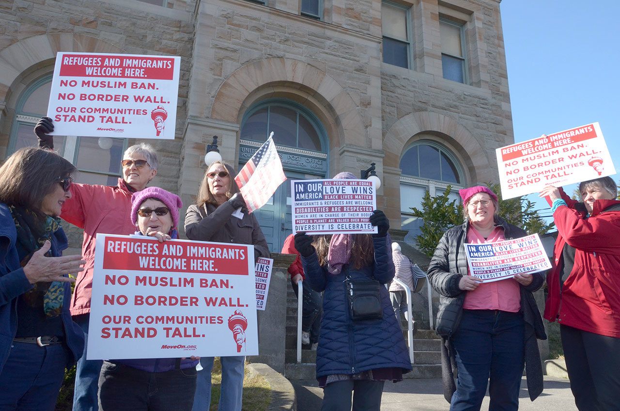 Roughly 60 people came out for a small protest outside the post office in Port Townsend on Monday to protest President Donald Trump’s proposed border wall and show support for immigrants. (Cydney McFarland/Peninsula Daily News)