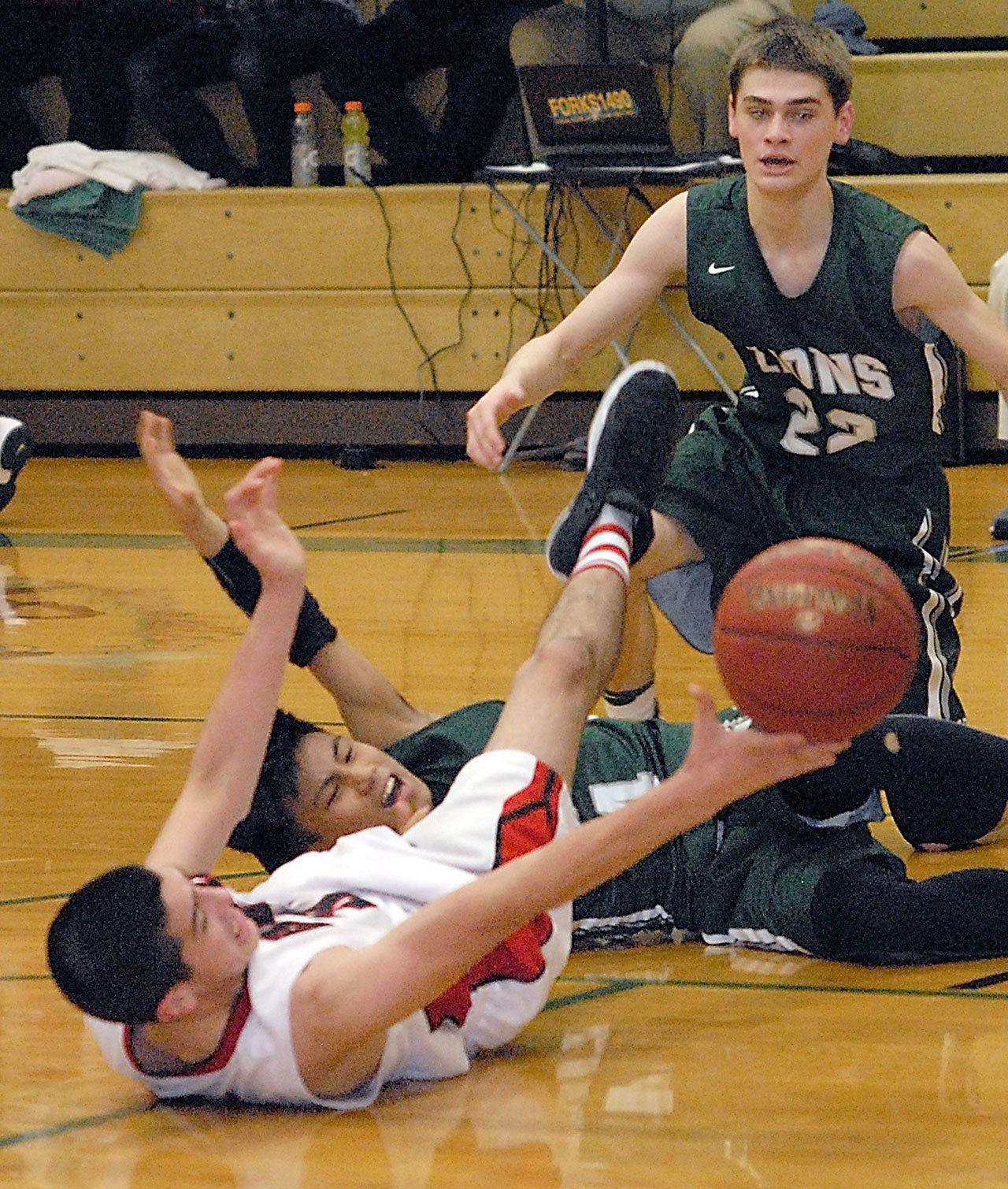 Keith Thorpe/Peninsula Daily News Neah Bay’s Cameron Moore, front, and Cedar Park Christian’s Sam Yaranon scramble for a loose ball as Cedar Park’s Jacob Schley looks on in the second quarter on Thursday at Port Angeles High School.