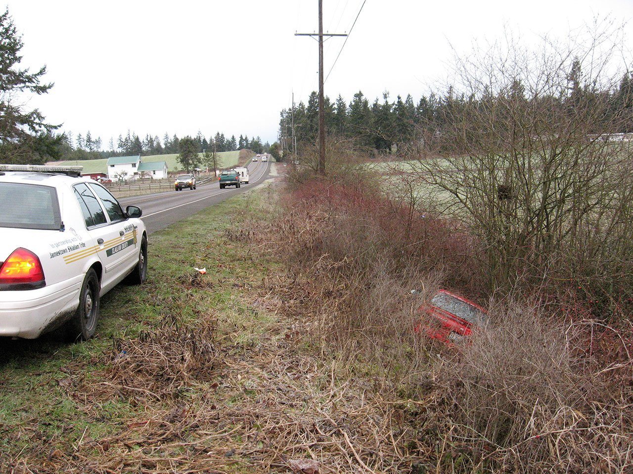 A Clallam County Sheriff’s Office cruiser sits along Sequim-Dungeness Way above a Toyota Celica found along the roadway Monday morning. A man walking a dog found the Toyota and called 9-1-1, leading to the rescue of a Sequim resident trapped inside. (Brandon Stoppani/Clallam County Sheriff’s Office)
