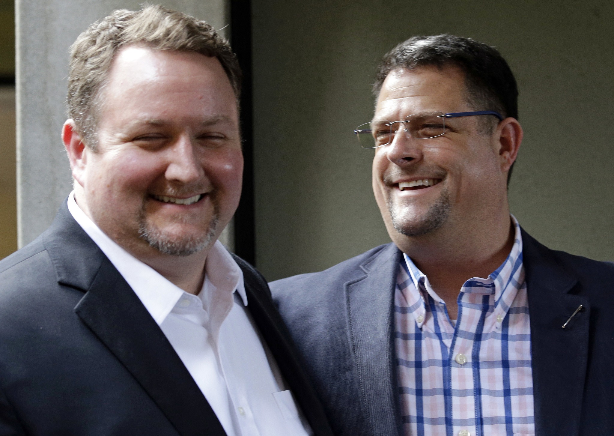 In this Nov. 15, 2016, photo, Curt Freed, left, and his husband, Robert Ingersoll, the couple who sued florist Barronelle Stutzman for refusing to provide services for their wedding, smile after a hearing before the state Supreme Court in Bellevue. (Elaine Thompson/The Associated Press)