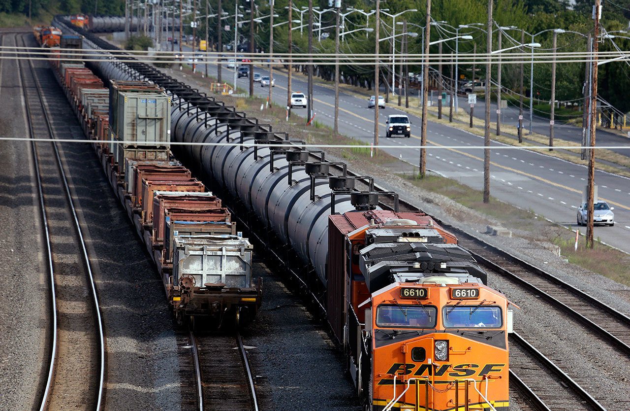 In this July 27, 2015, photo, traffic passes one of two mile-long oil trains parked near the King County Airport in Seattle. (Elaine Thompson/The Associated Press)