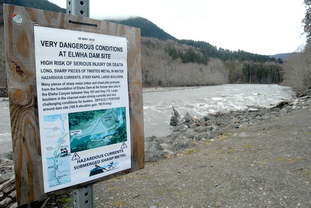 A warning sign near the entrance to Olympic National Park alerts rafters and kayakers to underwater dangers along the course of the Elwha River, remnants of the removal of the Glines Canyon and Elwha dams. (Keith Thorpe/Peninsula Daily News)