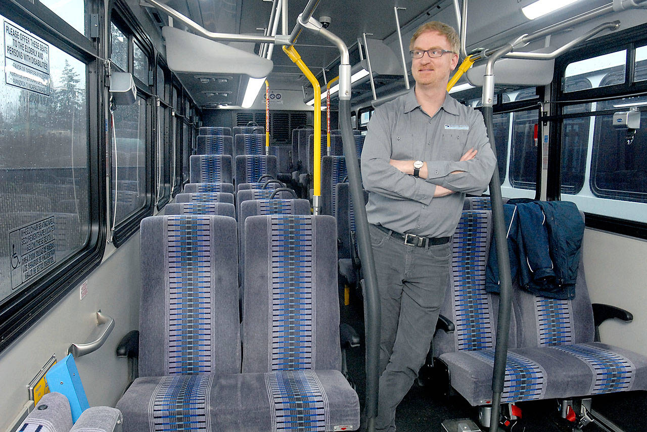 Clallam Transit operations manager Steve Hopkins stands in the aisle of a bus similar to the rolling stock being considered for a twice-daily run from Port Angeles and Sequim to Bainbridge Island. (Keith Thorpe/Peninsula Daily News)