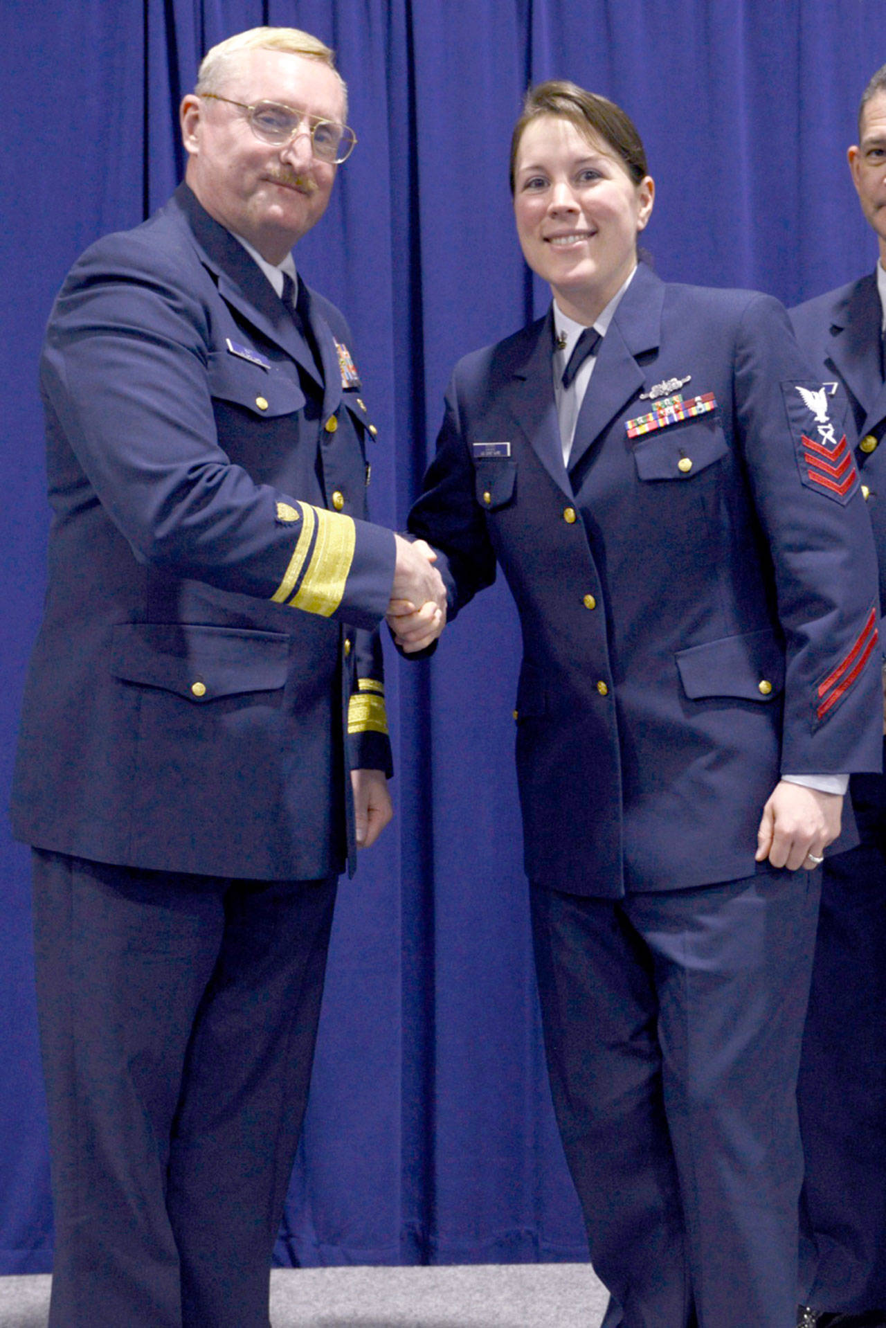 Rear Adm. Mark Butt, commander of the Coast Guard 13th District, shakes hands with Petty Officer 1st Class Tara Dodd after she was announced as the enlisted person of the year at a ceremony held at Coast Guard Base Seattle last week. (Amanda Norcross/U.S. Coast Guard)