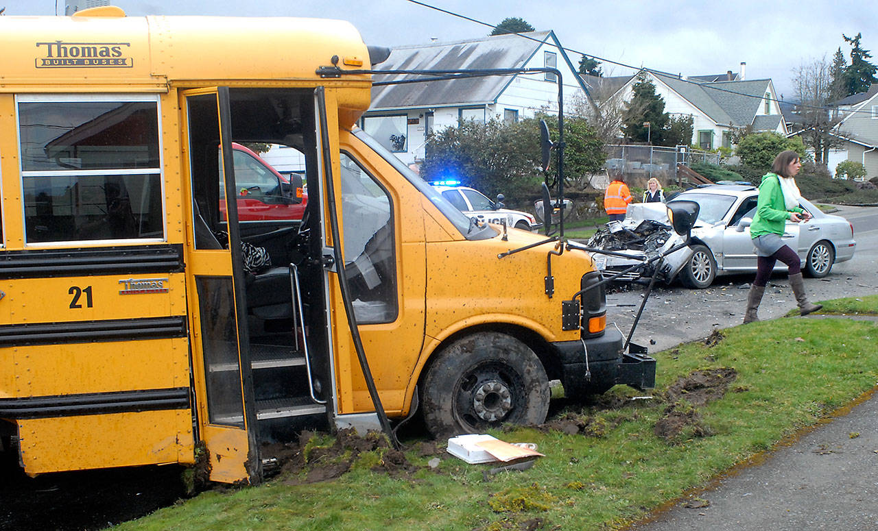 Jefferson Elementary School Principal Joyce Mininger, right, walks through the scene where a passenger car collided with a Port Angeles School District bus at 10th and Peabody streets in Port Angeles on Tuesday. (Keith Thorpe/Peninsula Daily News)
