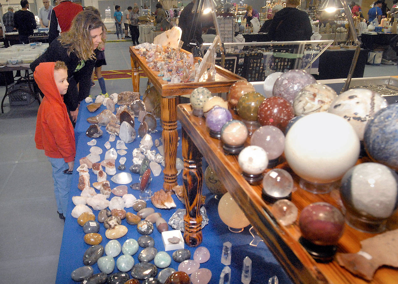 Julie Throop of Port Angeles and friend Brixton Martinez, 4, examine a table filled with rocks and gemstones operated by R&T Crystals and Beads of Sequim during the annual Rock, Gem and Jewelry Show last year at the Vern Burton Community Center in Port Angeles. (Keith Thorpe/Peninsula Daily News)